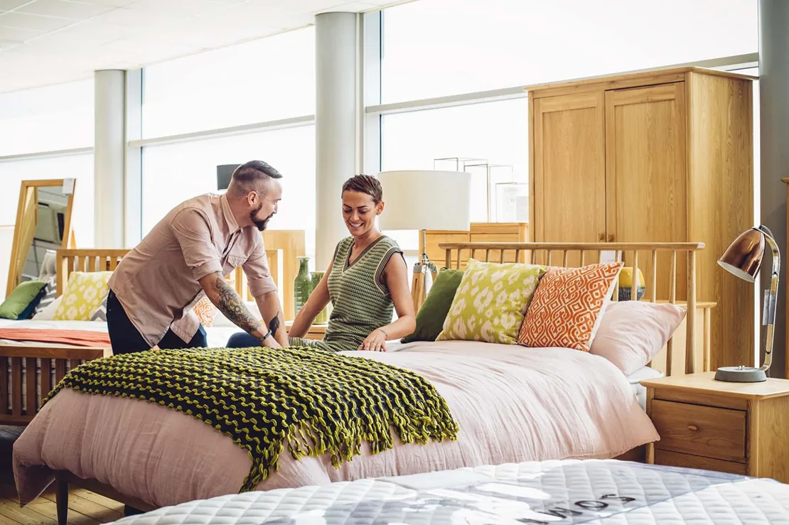 Man and woman sitting on bed in a shop