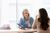Two people smiling during a consultation