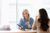 Two people smiling during a consultation