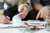 Two people discussing their finances, a notepad and calculator in front of them
