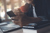 Man with a coffee looking at his phone with his laptop open