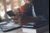 Man with a coffee looking at his phone with his laptop open