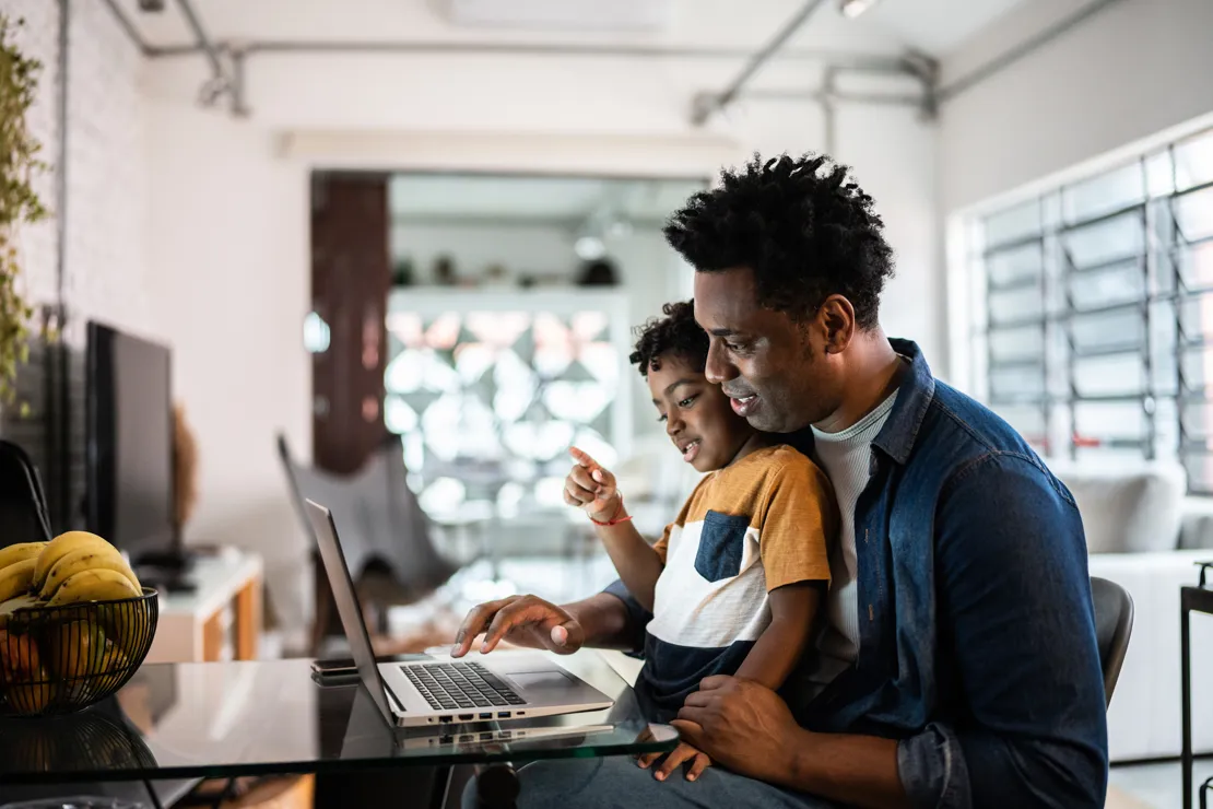 Man And His Son Looking At A Computer