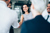 Businesswoman shaking hands with a man in a white shirt, with colleagues standing around them
