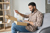 Man in a checked shirt unpackaging a package sent by a retailer