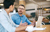 Two businesspeople talking over a coffee, looking at a laptop