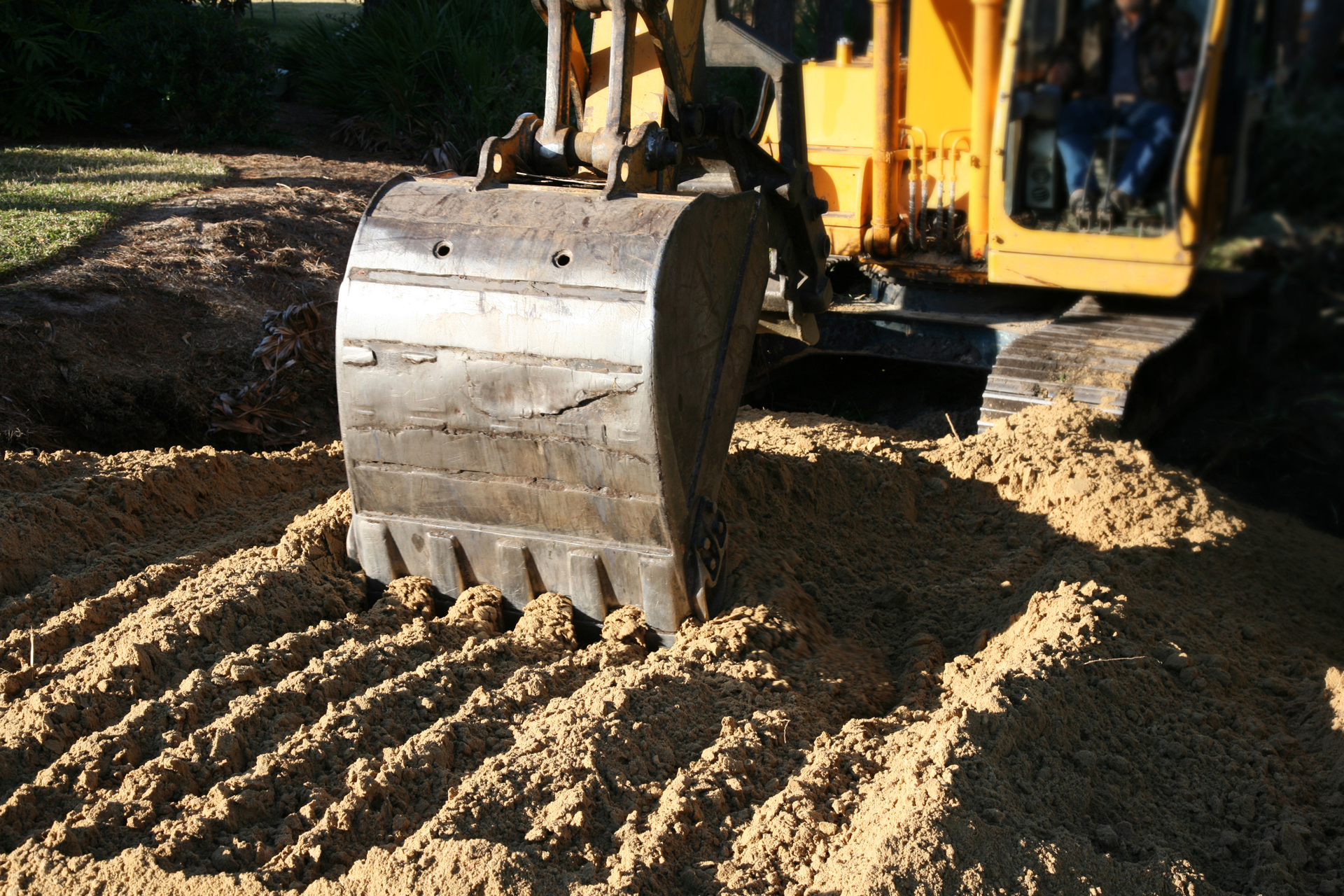 Excavator Back Hoe Spreading Dirt For Progress And Development 471153335