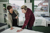 Young man in a furniture shop talking to a retailer while looking for a new mattress