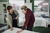 Young man in a furniture shop talking to a retailer while looking for a new mattress