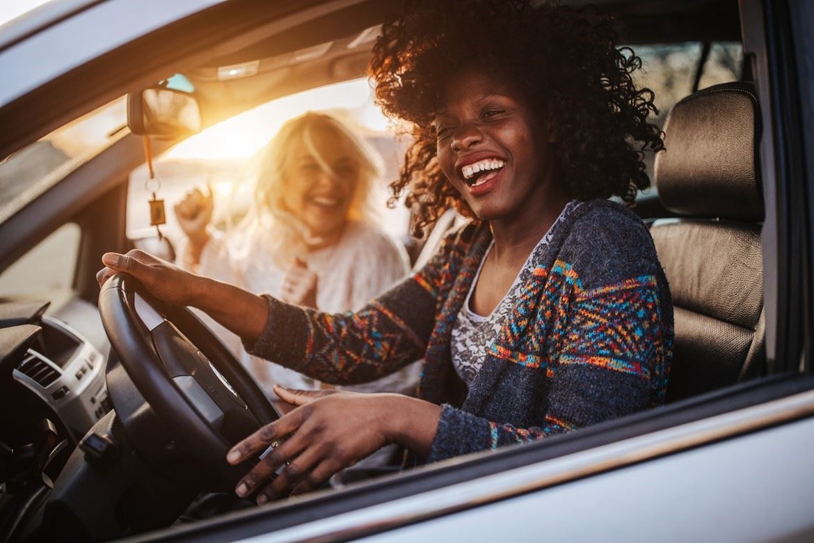 Two woman sat laughing in a car