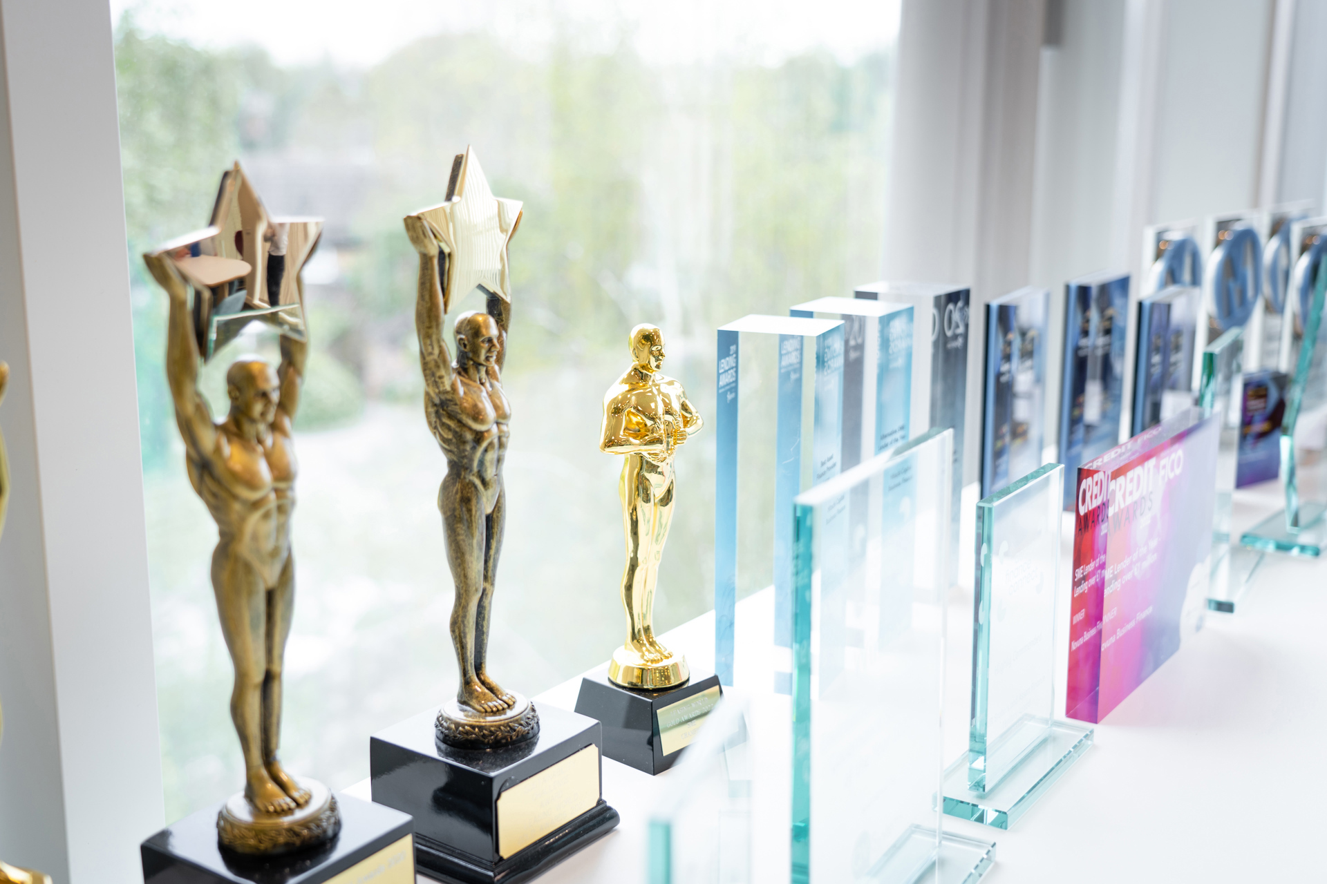 Novuna trophies and industry awards displayed on a bright windowsill