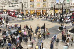A busy high street in London with dozens of shoppers walking around