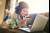 Woman lounging on her sofa shopping online with a credit card